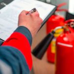 Técnico revisando extintores en una comunidad de propietarios
